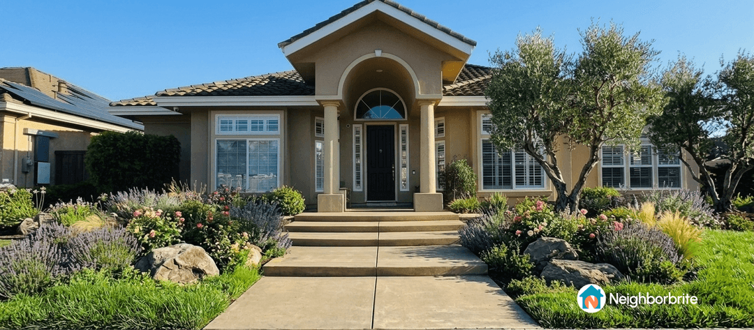 A well-designed front yard with a retaining wall and colorful flowers.