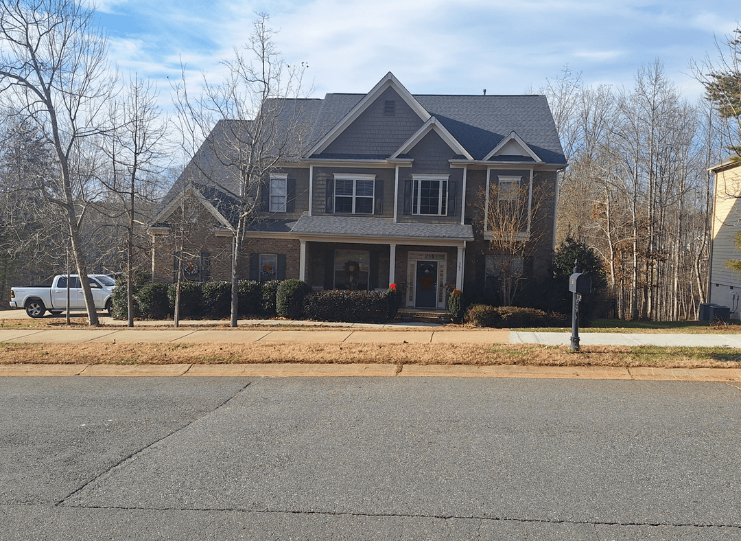 A house with bare trees, seeking to remove them and add a walkway and landscaping.