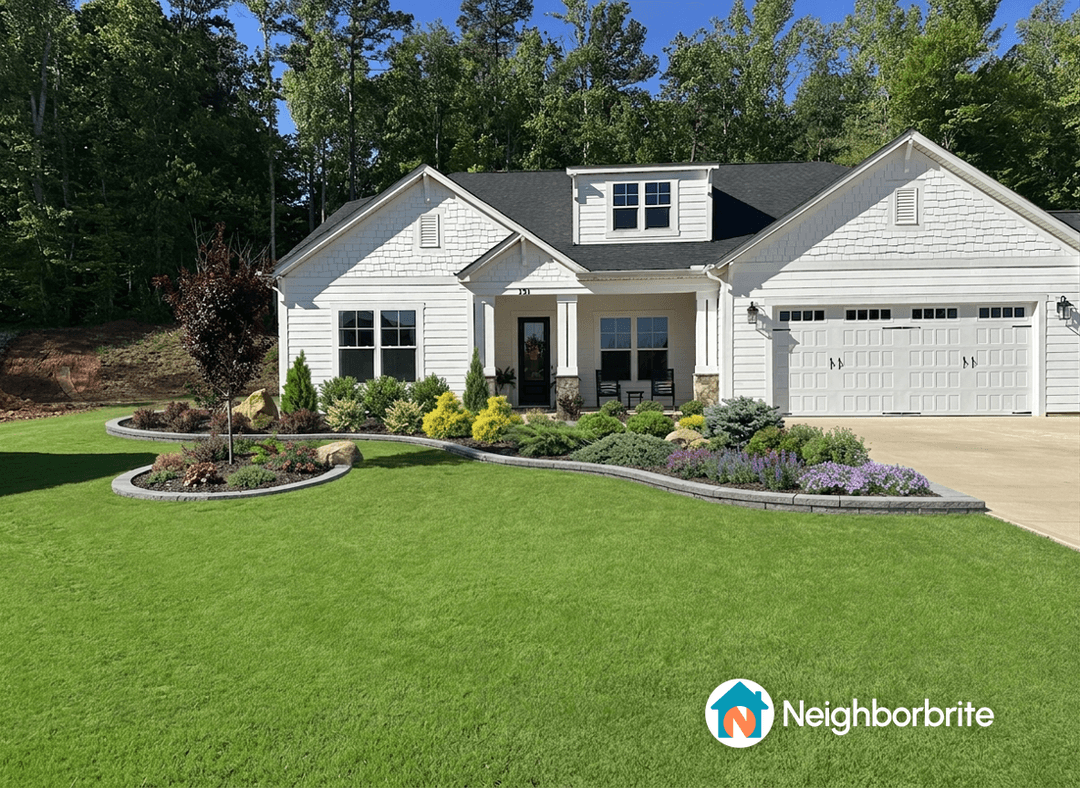 A well-maintained front yard with landscaping near a driveway.