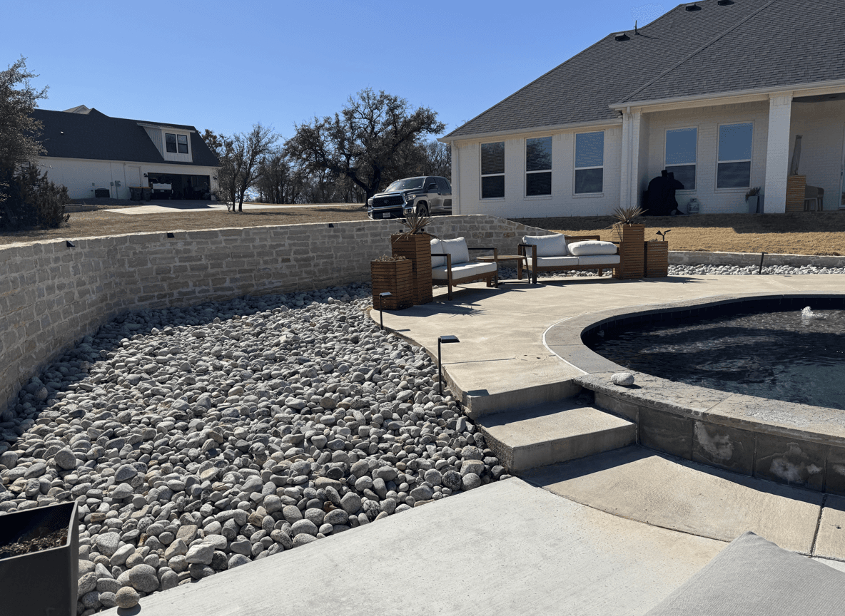 A modern yard with rocks and seating, looking for plant suggestions.