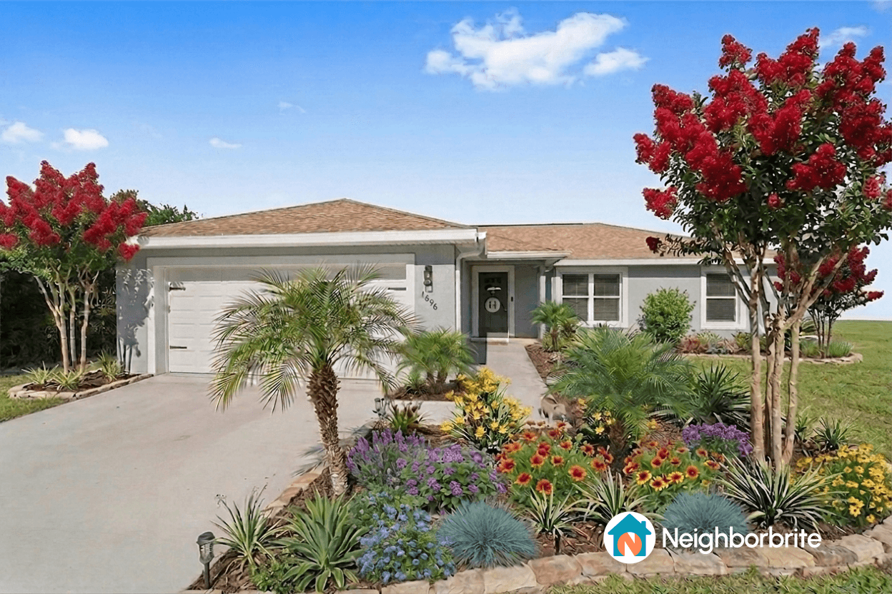 Front yard with colorful flowers and trees in full sun.