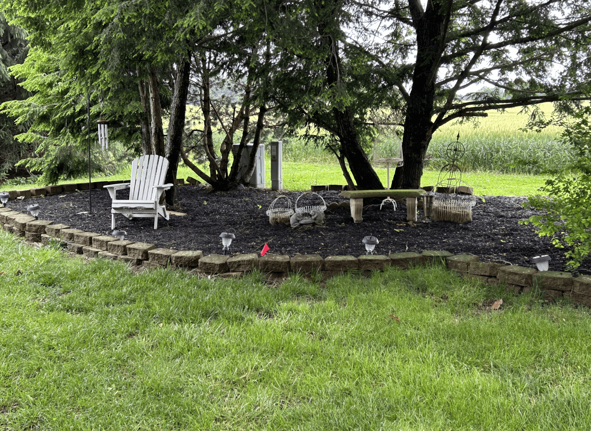 A landscaped area with seating, decorative items, and trees.