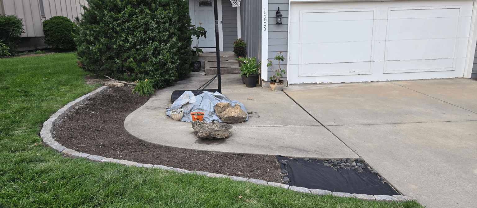 A yard area with rocks, mulch, and landscaping materials for improvement.