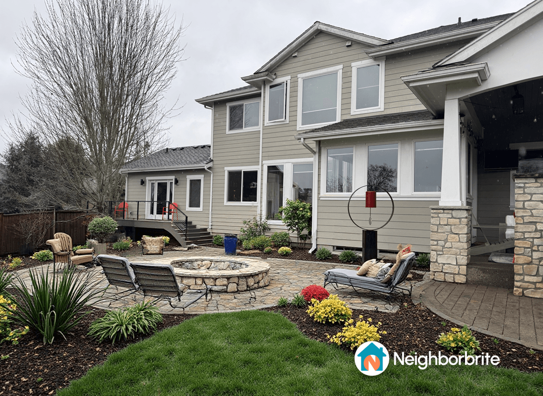 A landscaped yard with a fire pit and seating area.