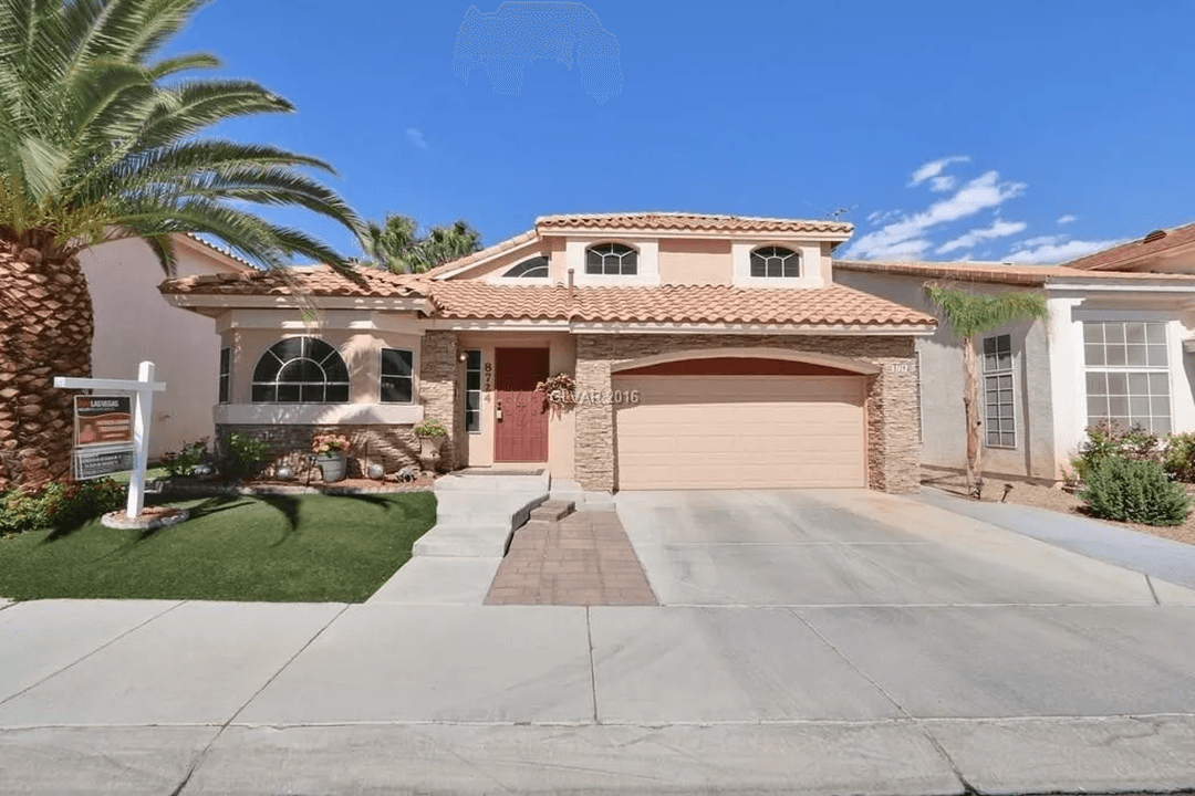 Front yard with turf, palm trees, and a house facade.