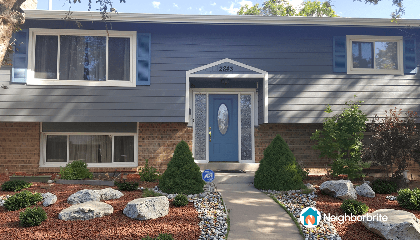 Front view of a house with landscaping and a blue door.
