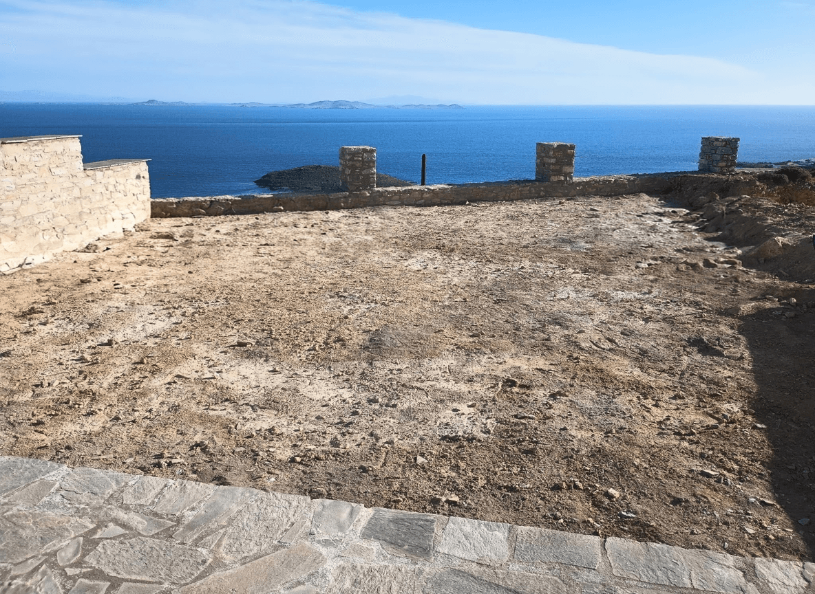 A cleared area with a view of the sea, ready for a swimming pool installation.