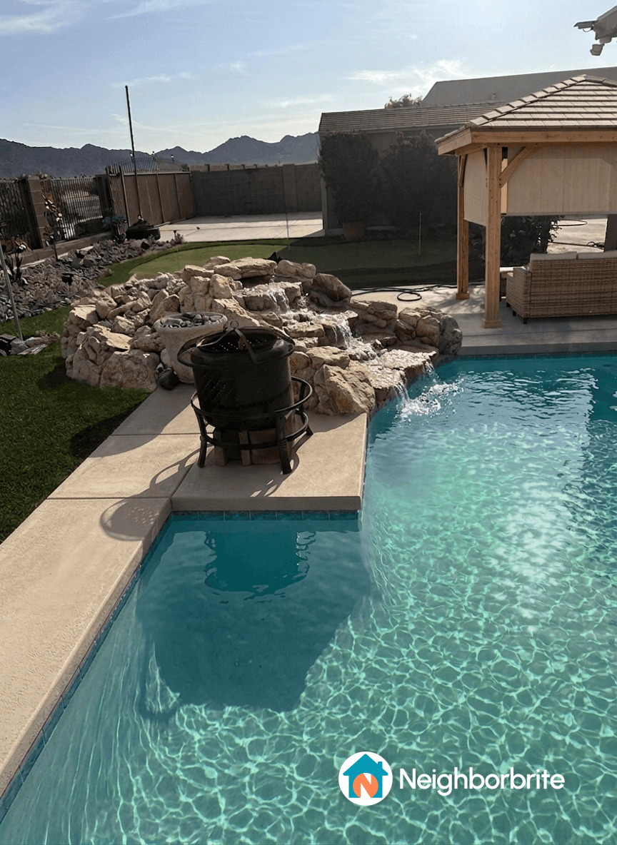 View of a pool area with a gazebo and landscaping features.