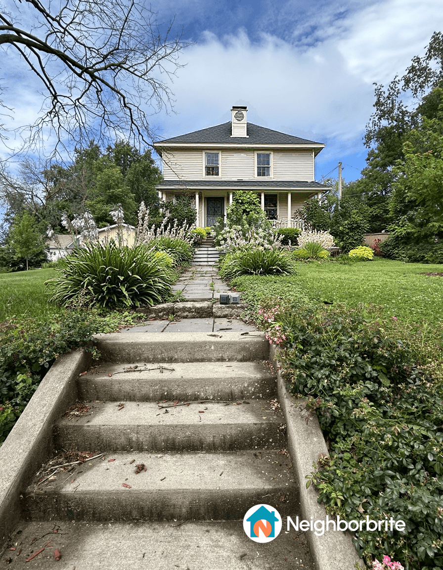Front view of a house with steps and garden after tree loss.