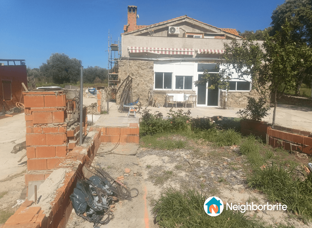 A construction site with a house and area for a new pool.