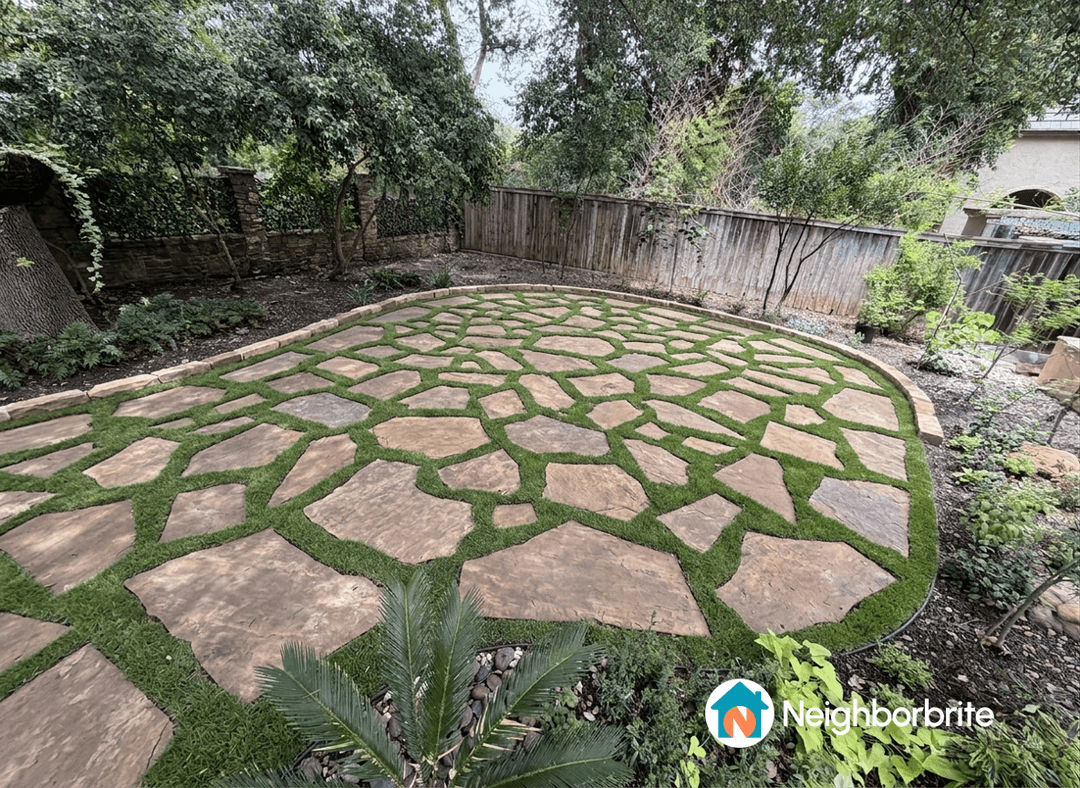 A landscaped yard with flagstone and grass, suggesting larger stones.