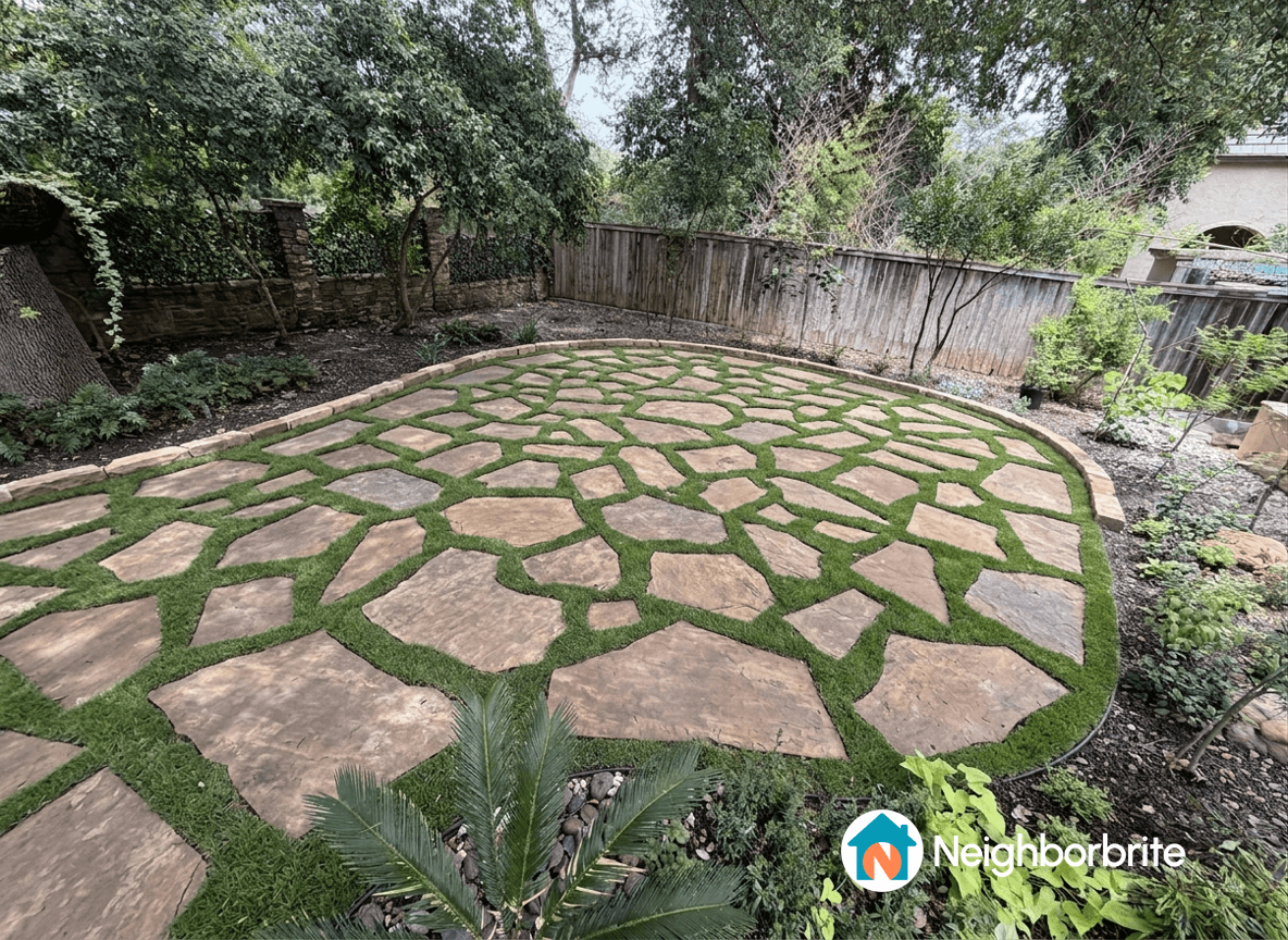 A landscaped yard with flagstone and grass, suggesting larger stones.