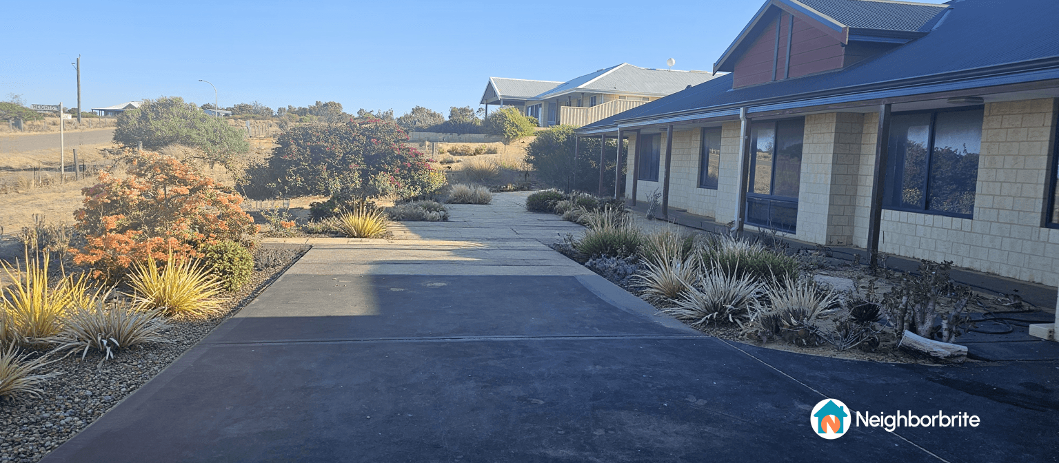 A landscaped yard featuring a stone pathway and colorful plants.