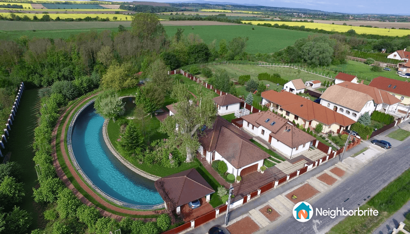 Aerial view of a property with a pool and landscaped yard.
