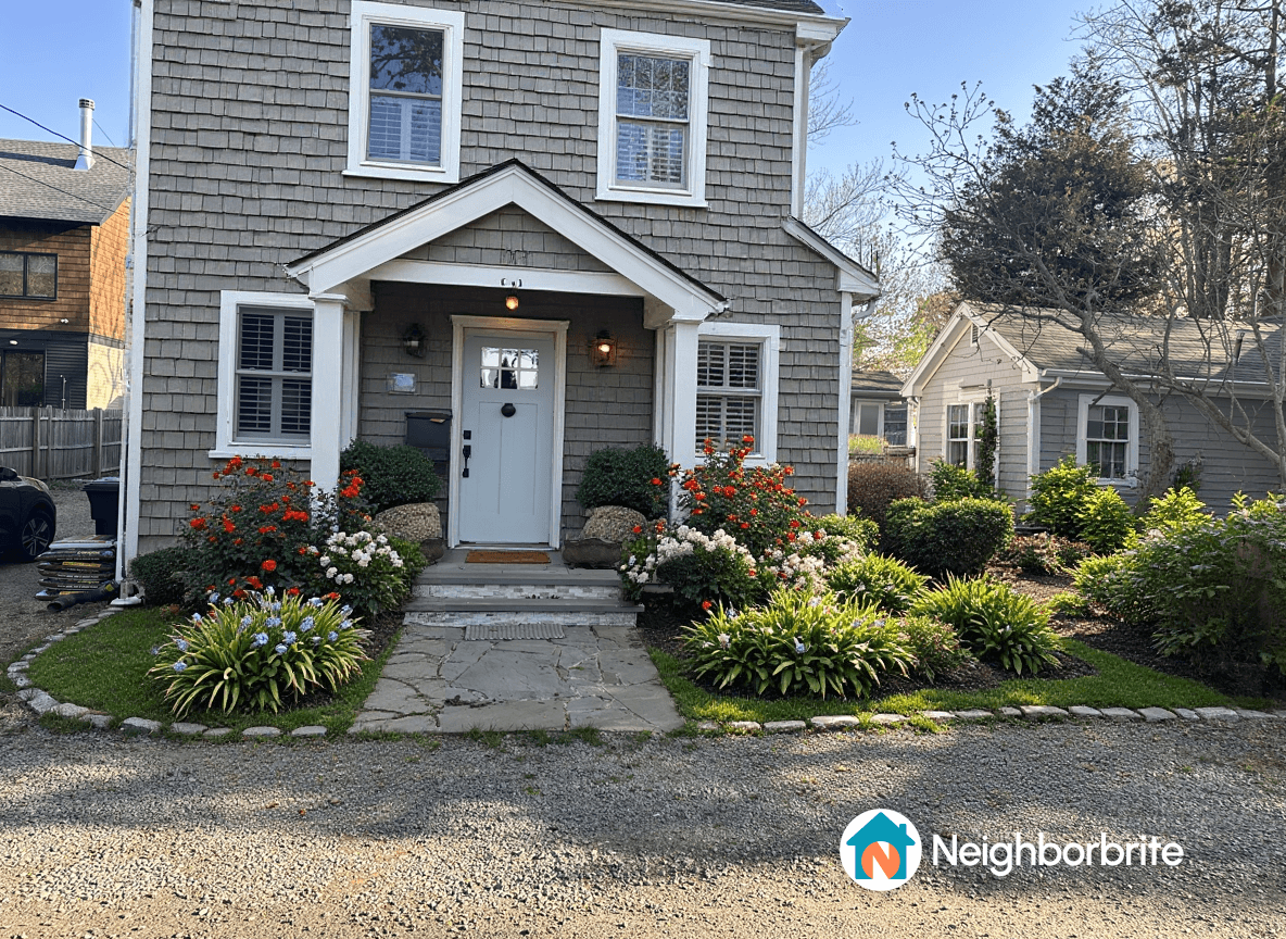 A well-maintained front yard with various flowering plants and shrubs.