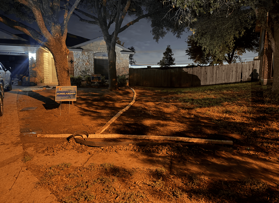 A yard with a tree, showing a planned area for grass, mulch, and rock pebbles.