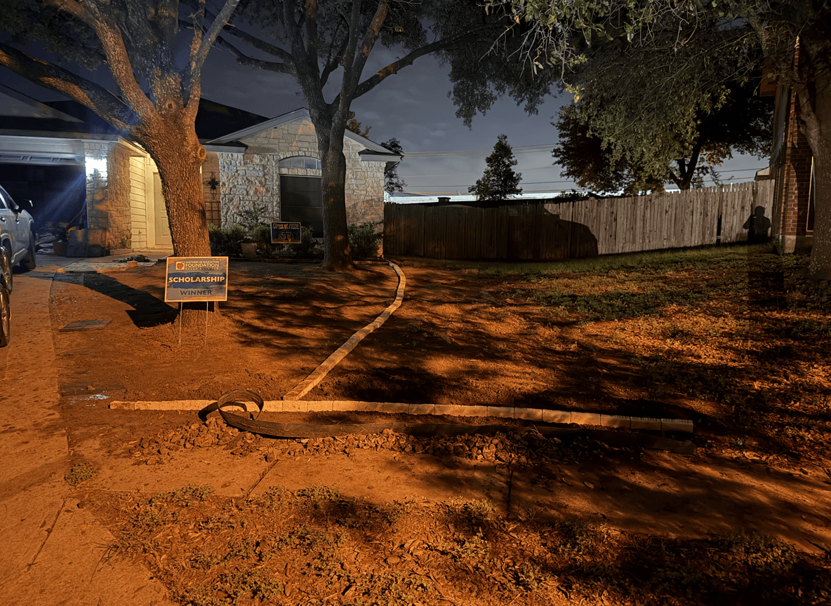 A yard with a tree, showing a planned area for grass, mulch, and rock pebbles.
