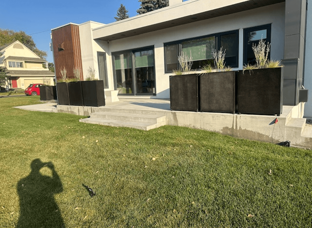 Modern residential dwelling with planters on a corner lot.