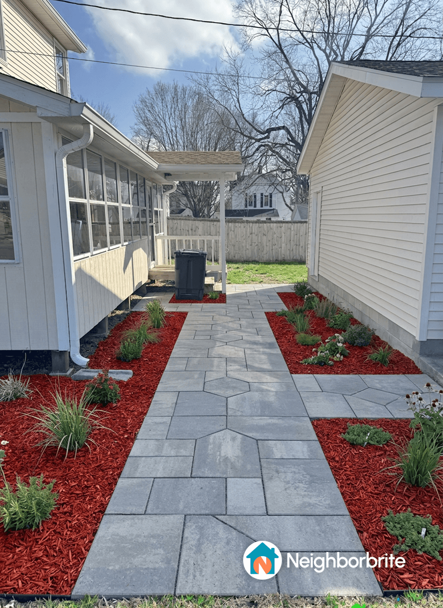 Pathway with red mulch and pavers connecting two structures.