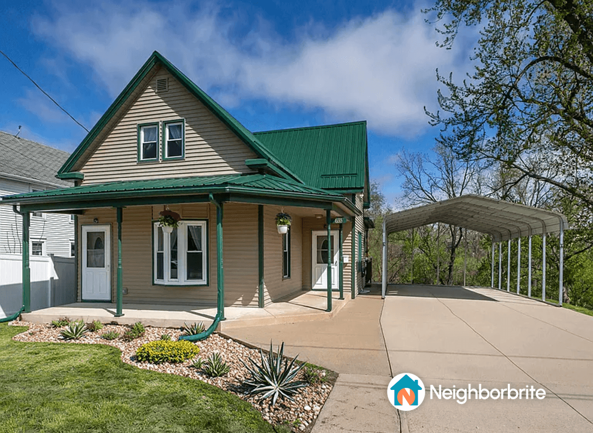 A house with a green roof and landscaped yard, seeking project cost estimates.