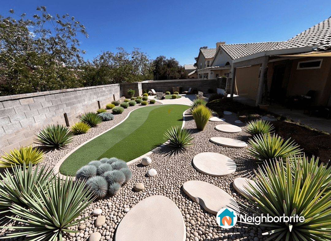 A beautifully designed landscape with greenery, stones, and a pathway.