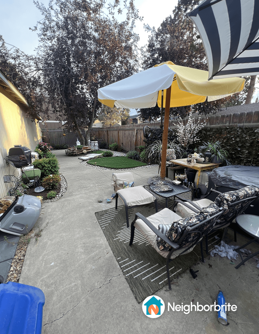 A backyard with seating, umbrellas, and garden features.