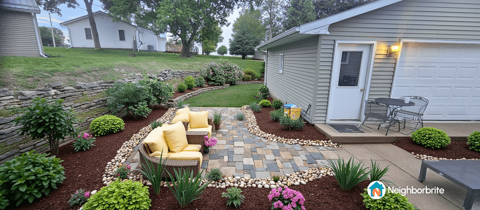A cozy outdoor area with yellow chairs, stone path, and lush greenery.