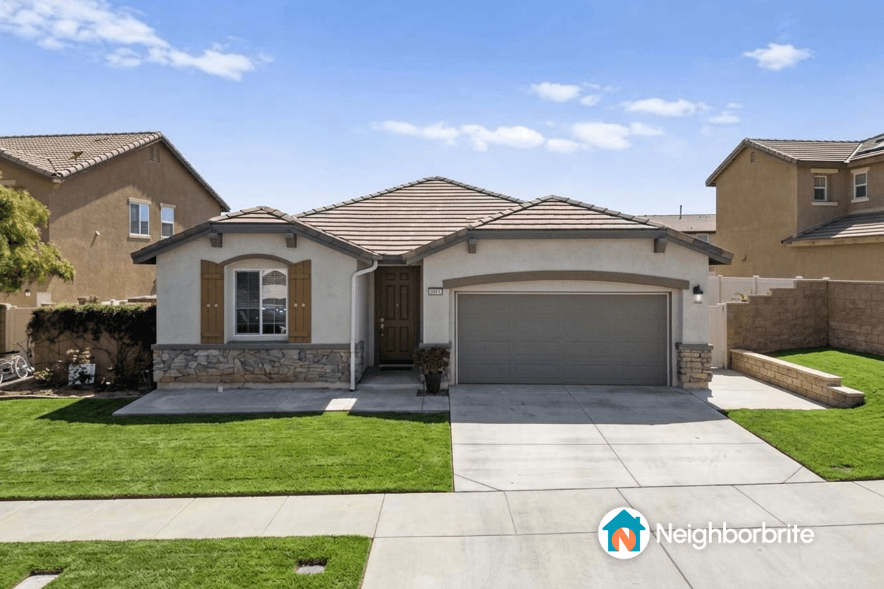 A well-maintained home with a green lawn and stone accents.