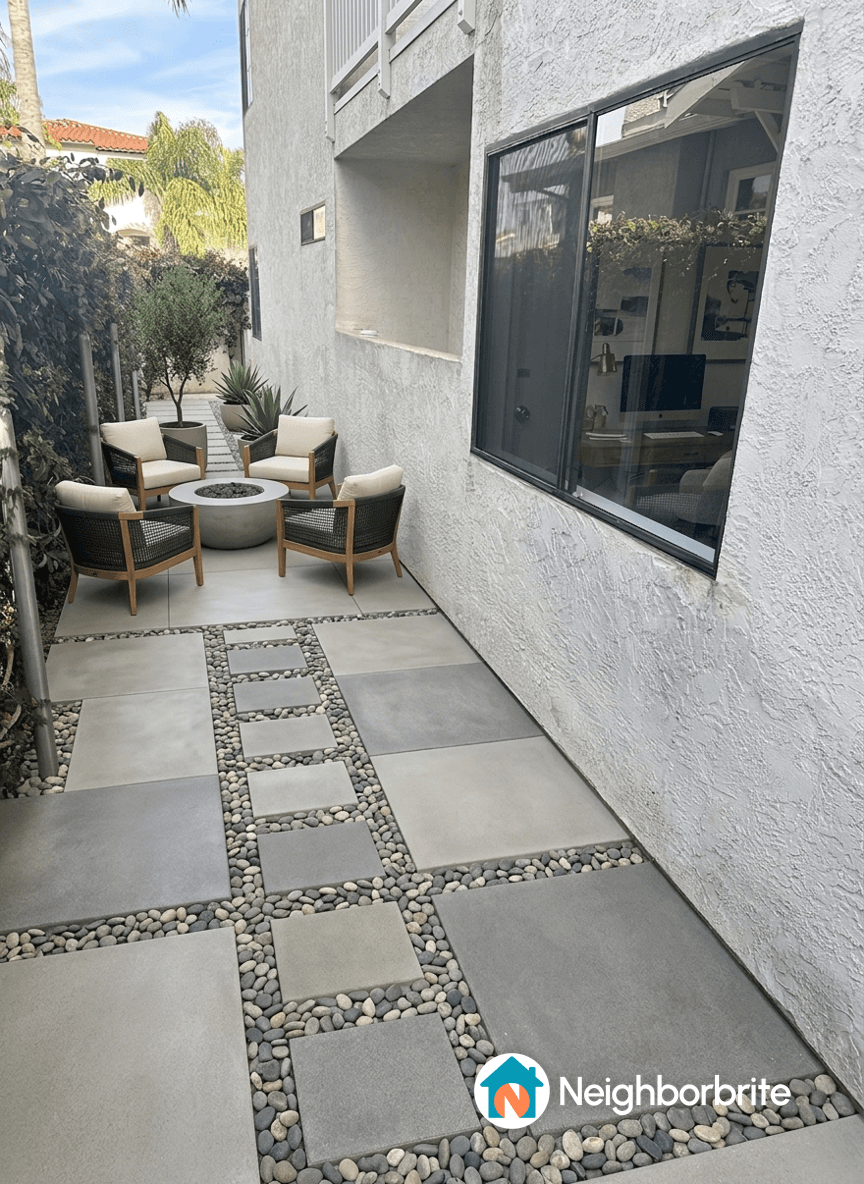 A patio area with seating and decorative stones, asking to remove a pony wall.
