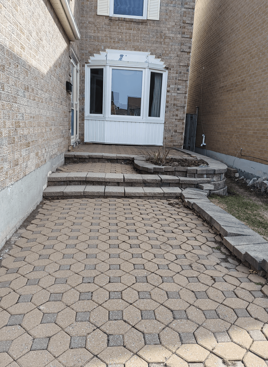 A front entrance with a stone pathway and a small flower bed.