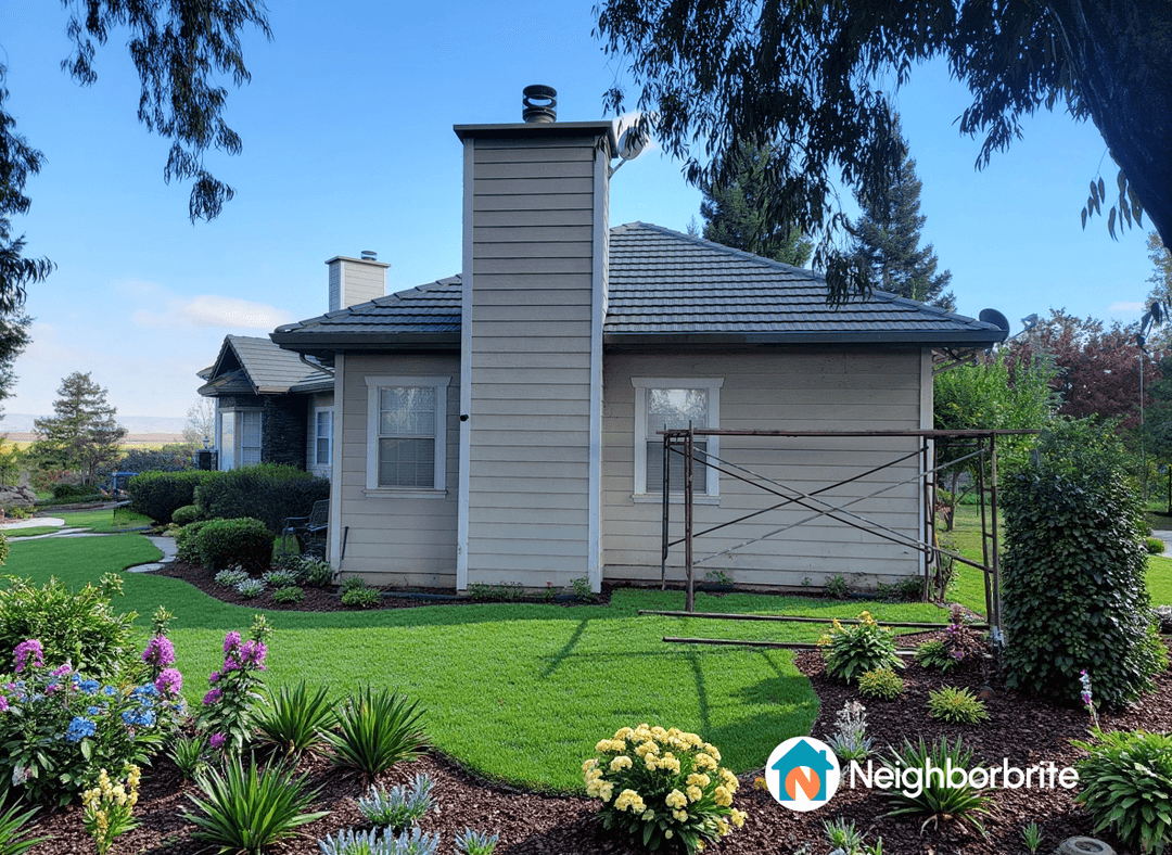 A well-maintained yard under eucalyptus trees with colorful flowers.