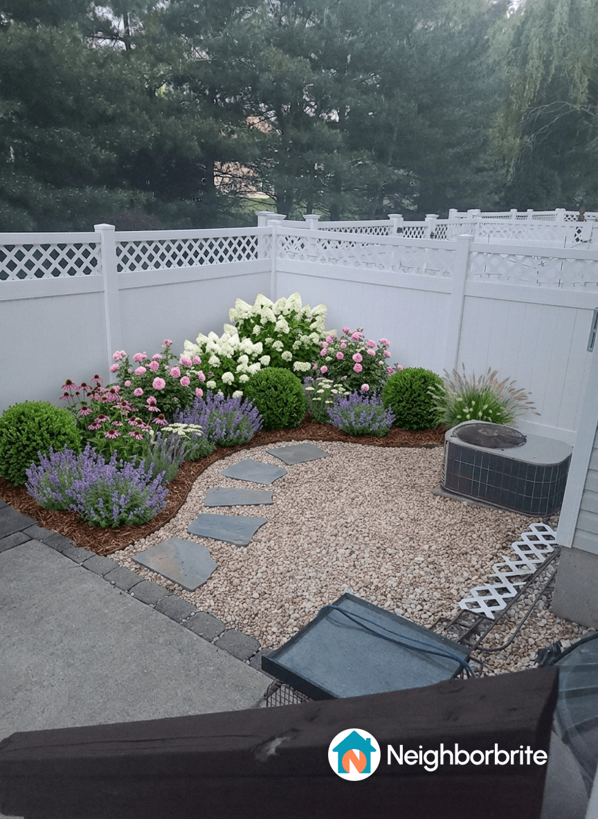 A landscaped garden with flowers, shrubs, and stone path.