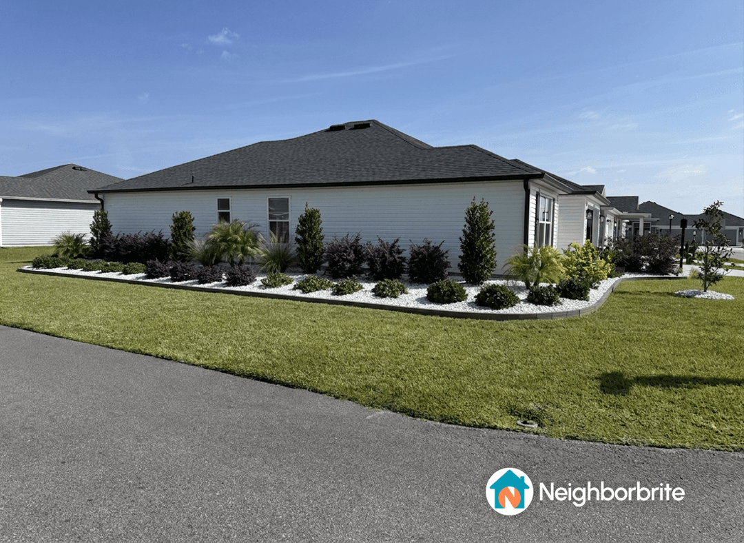 A landscaped yard with colorful plants and bushes along a house.