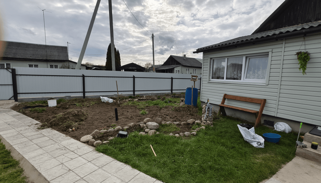 Garden area with stones, tools, and plants for a floral design.