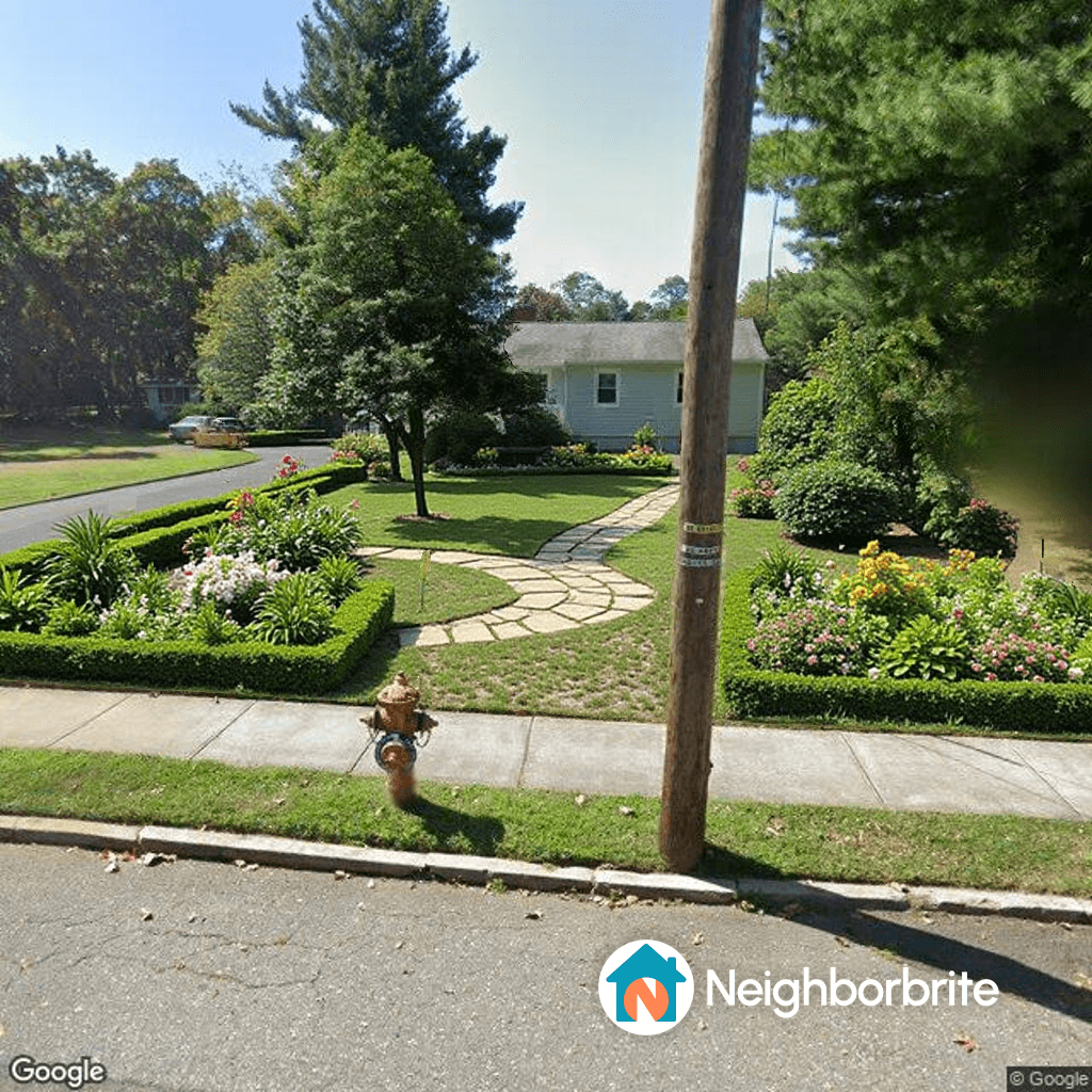 A landscaped yard with a stone path and colorful flowers.