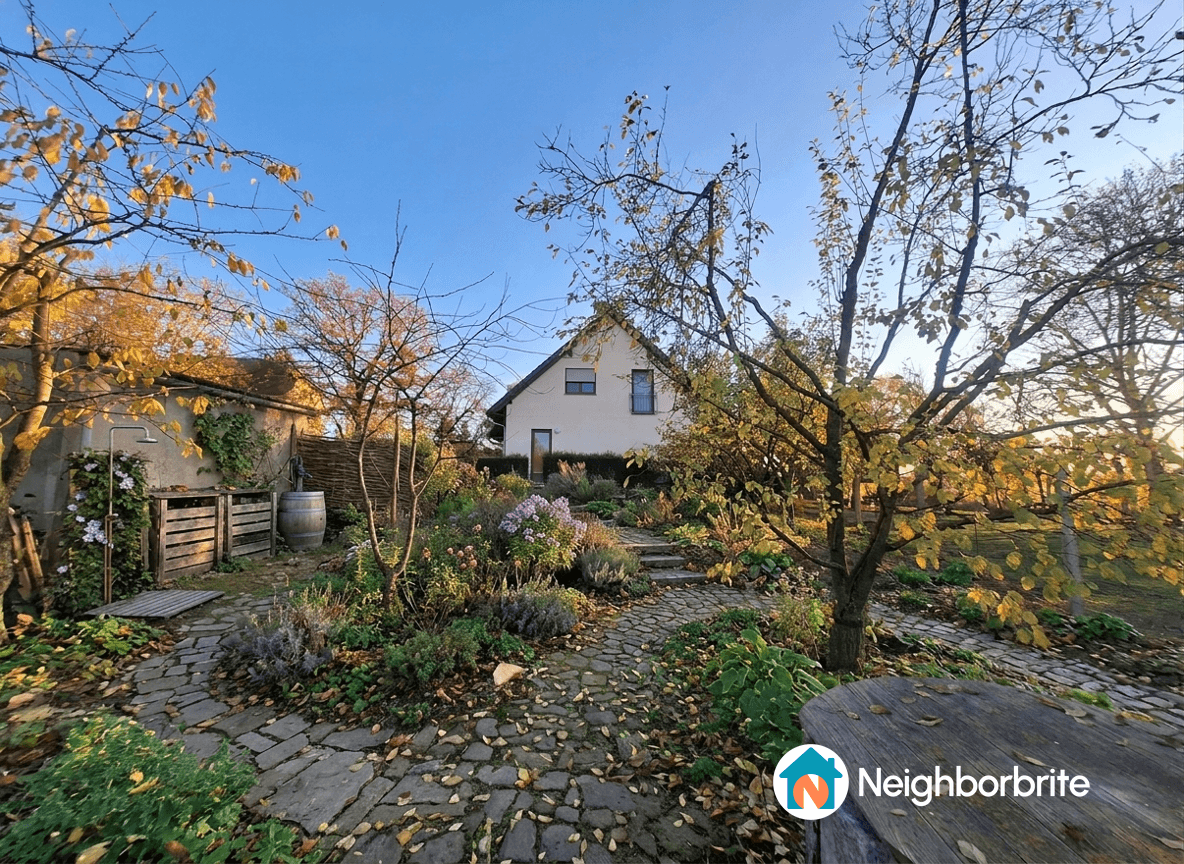 A scenic garden with a stone path, flowers, and a house in the background.