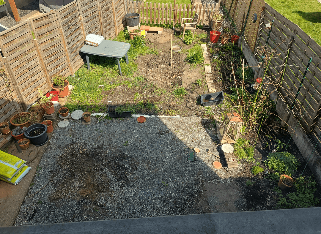 A garden area with a table, pots, and a barbecue corner.
