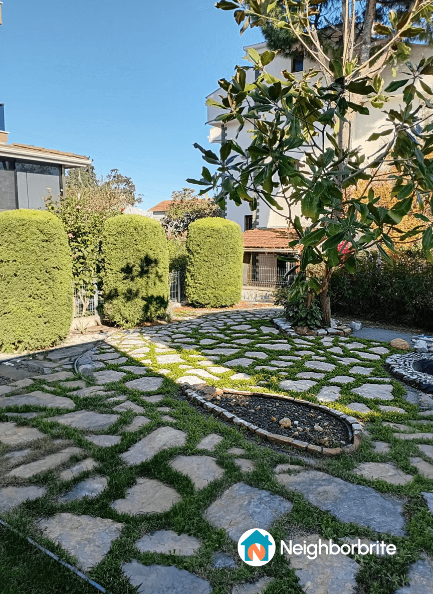A landscaped yard with stone pathways and greenery.