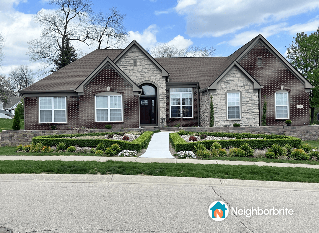 A well-maintained home with landscaped garden beds and a clear sky.