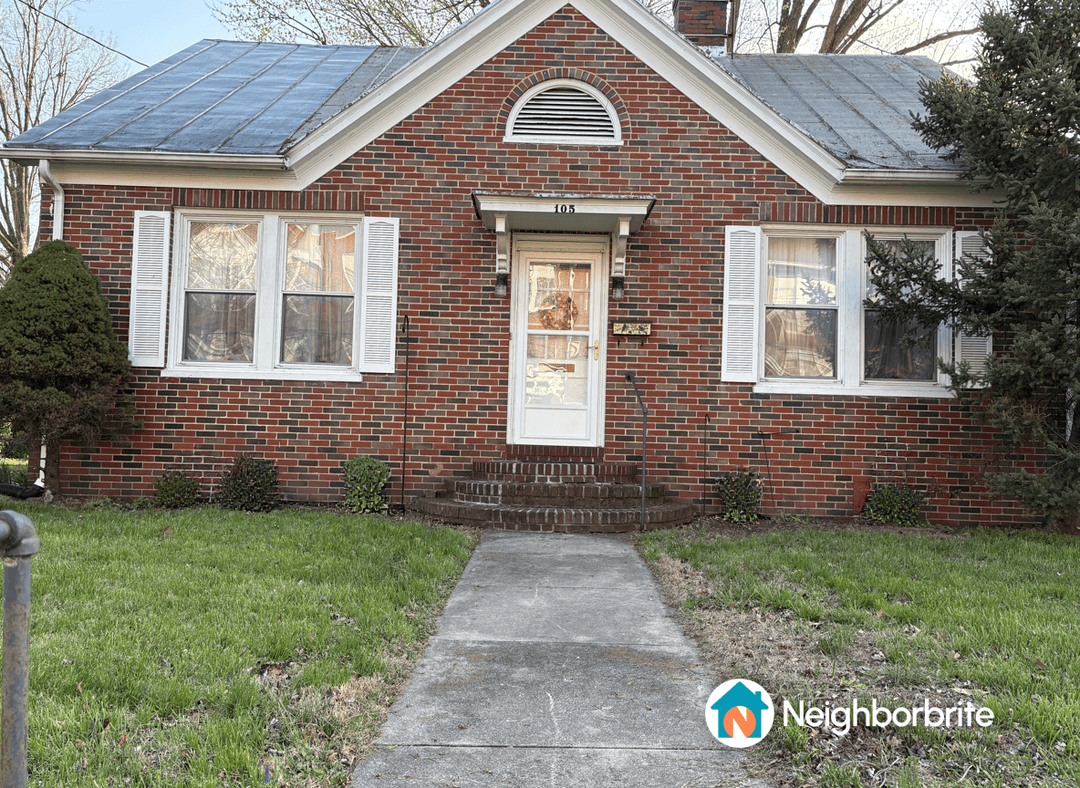 Front view of a brick house with a walkway and landscaping.