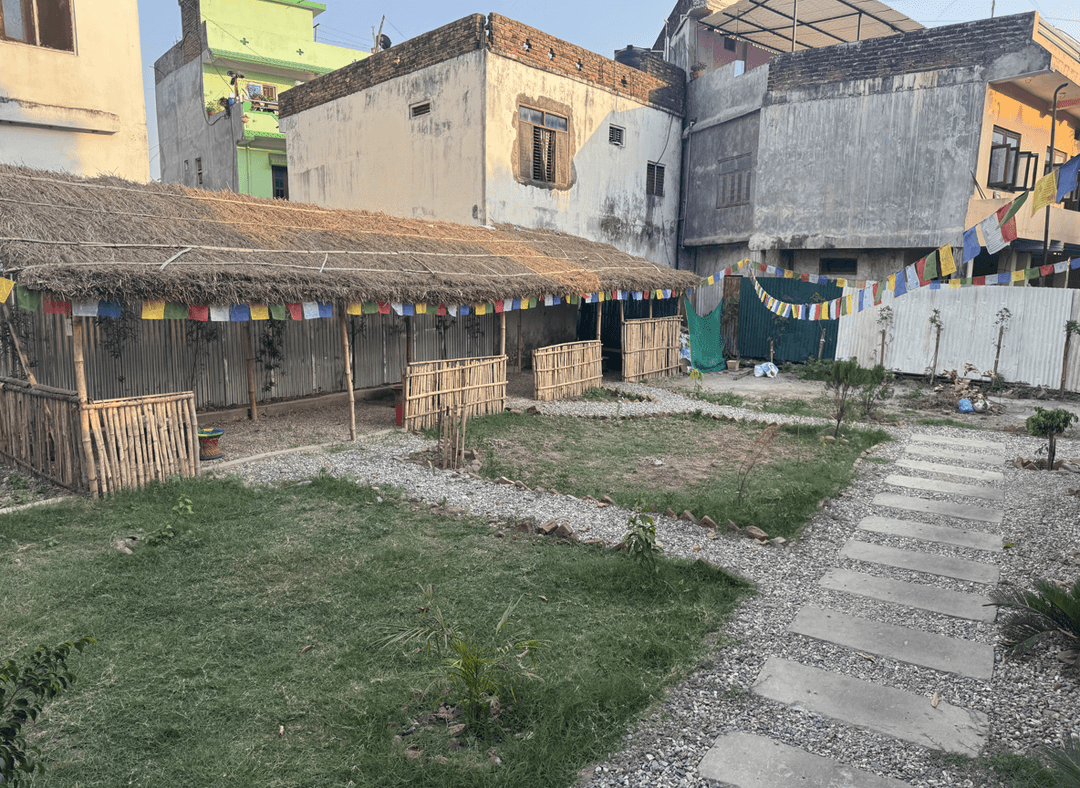 Outdoor restaurant area with bamboo structures and colorful flags.