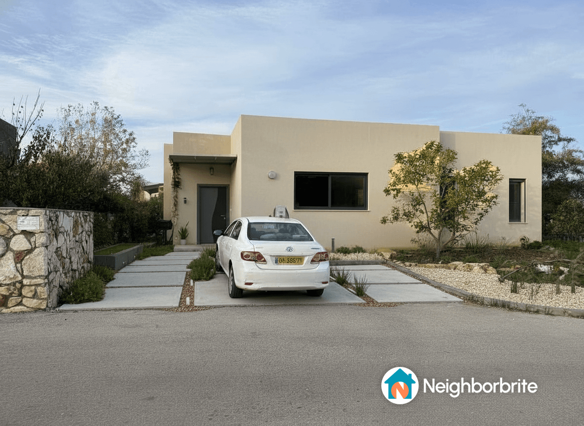 A modern home with a white car parked in front and landscaped garden.