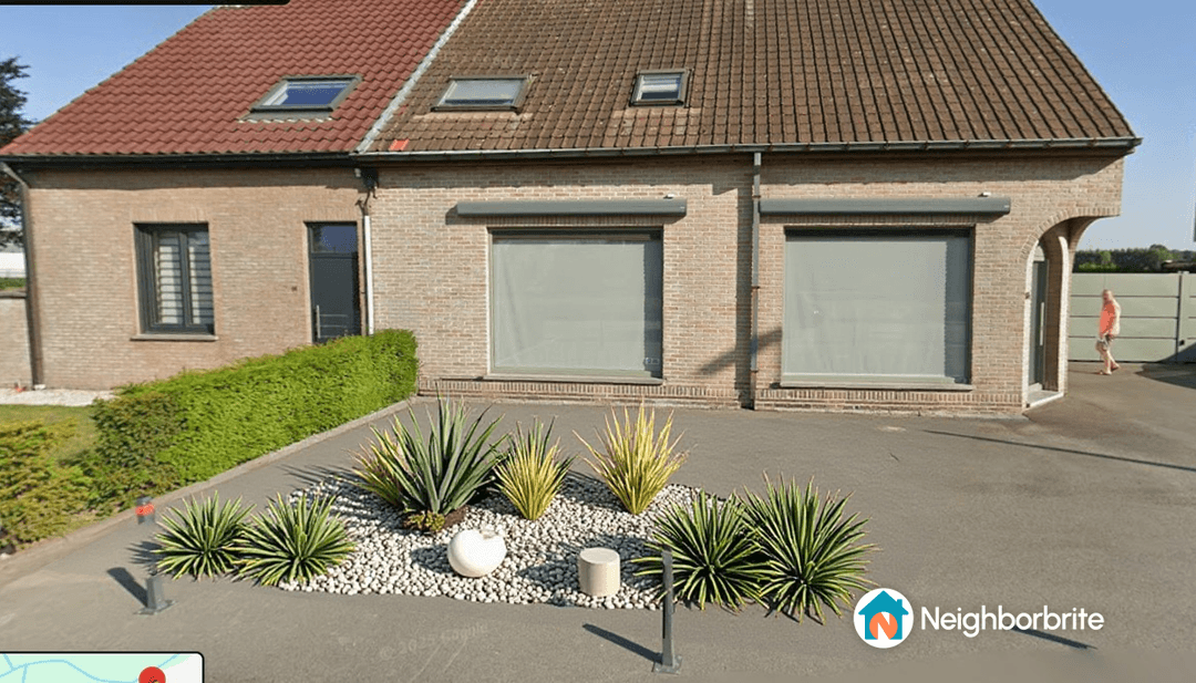 A modern home with flower boxes featuring artificial grass and decorative plants.