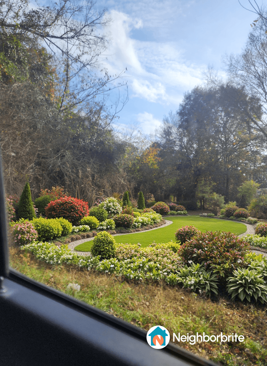 A lush garden with dense flower beds and manicured lawns.