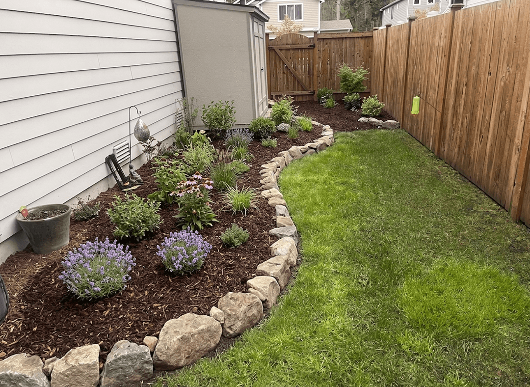 A landscaped yard with flowers and a grassy area, asking about adding rock.