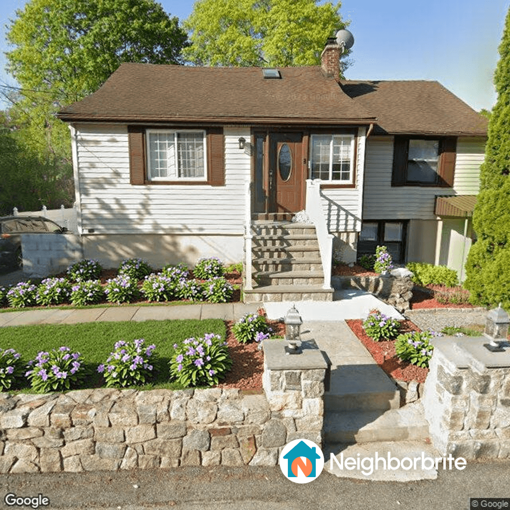 Front yard with flowers and a foundation wall needing coverage.