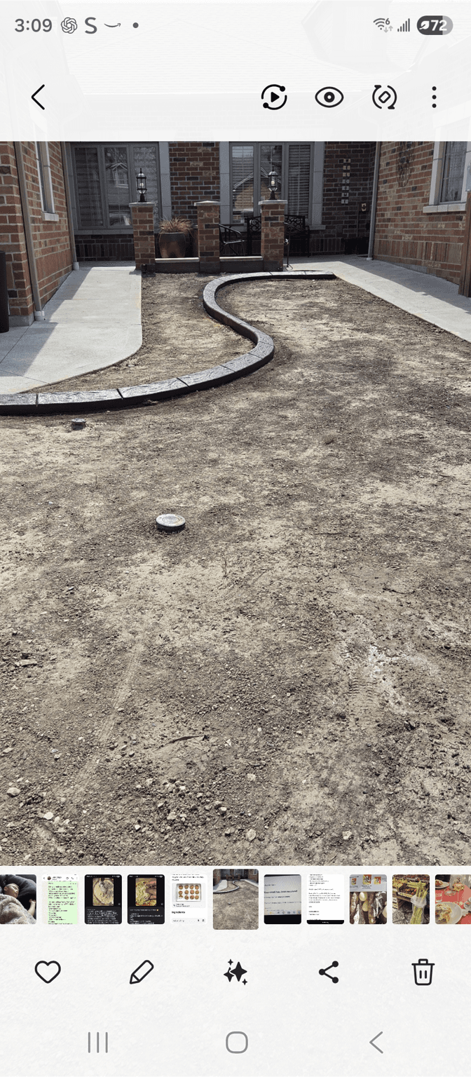 A front yard with a curved stone pathway and bare soil.