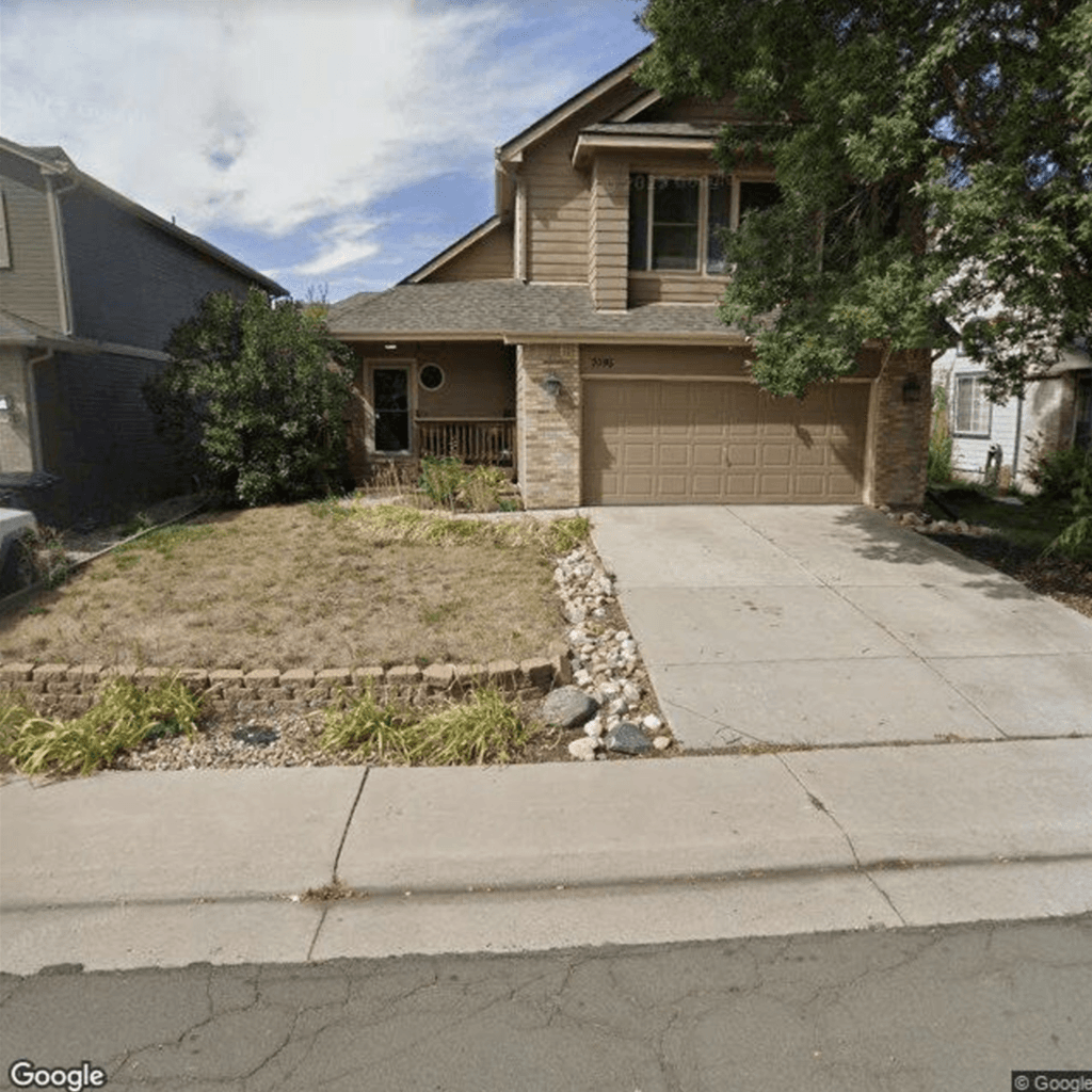 Front yard with paver wall, porch, and sitting areas.