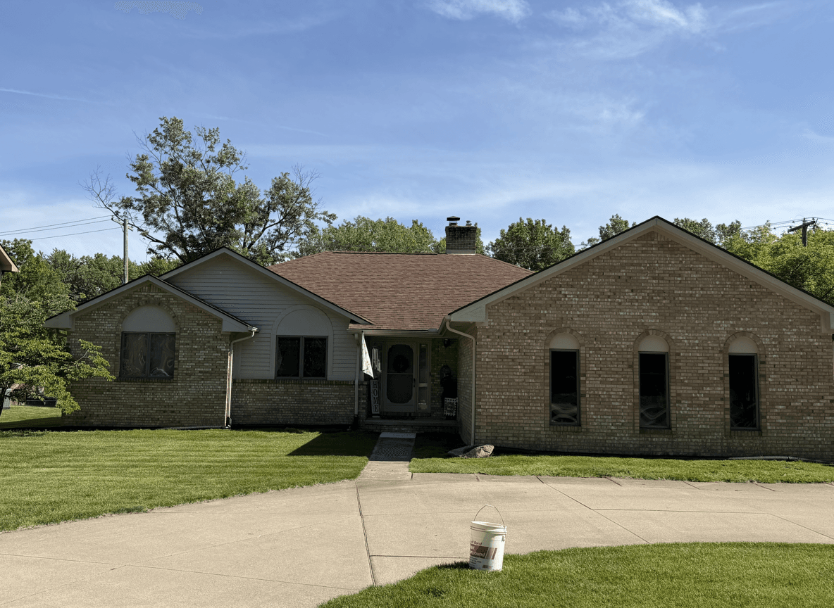 Front view of a house with a well-maintained lawn and clear sky.
