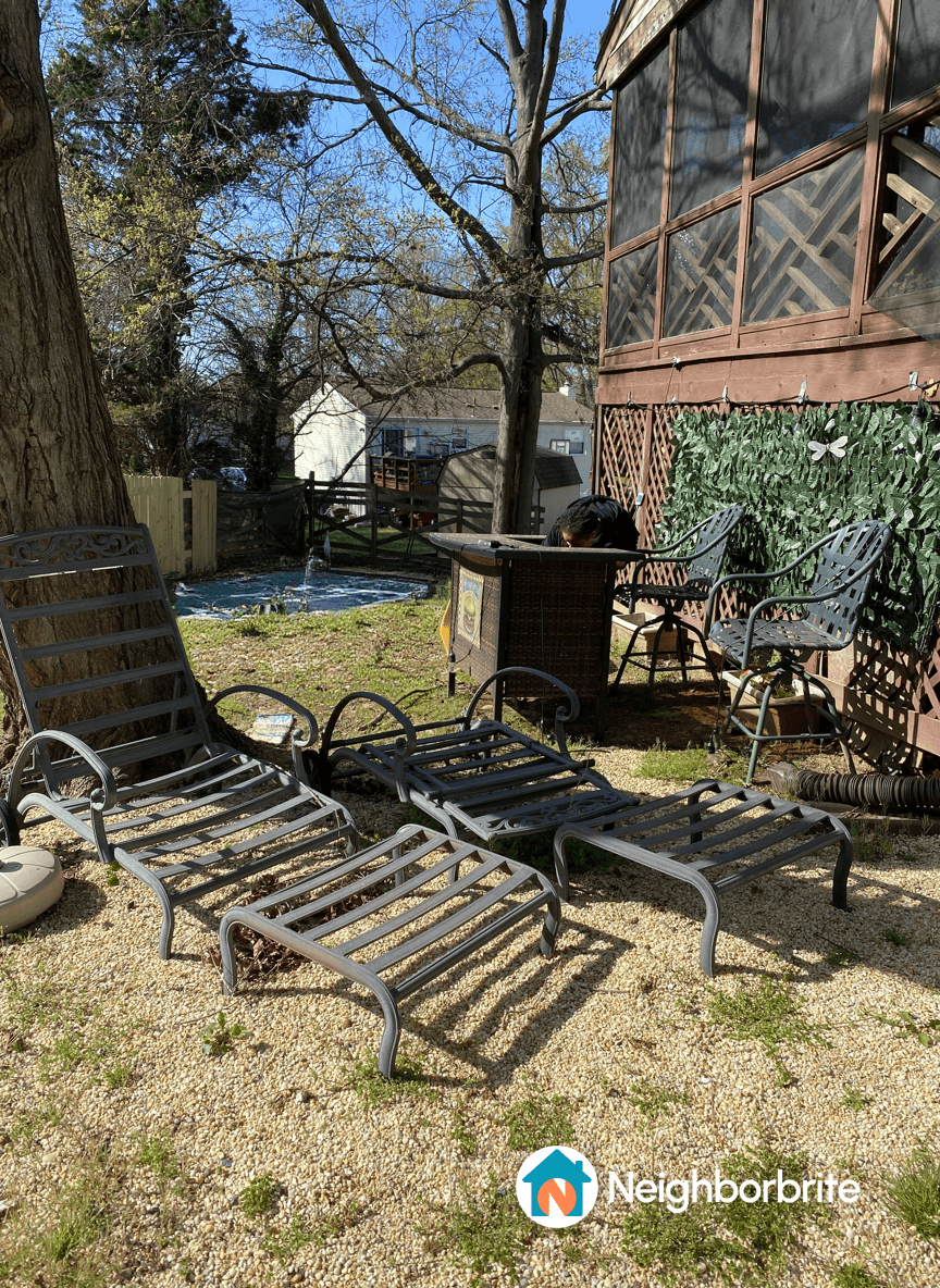 A backyard scene with lounge chairs and a view of a pool area.